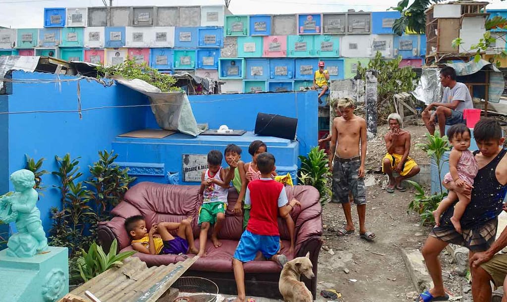 Manila Nordfriedhof, Großfamilie mit Wand mit Urnengräbern im Hintergrund, Copyright Peter Pohle PetersTravel