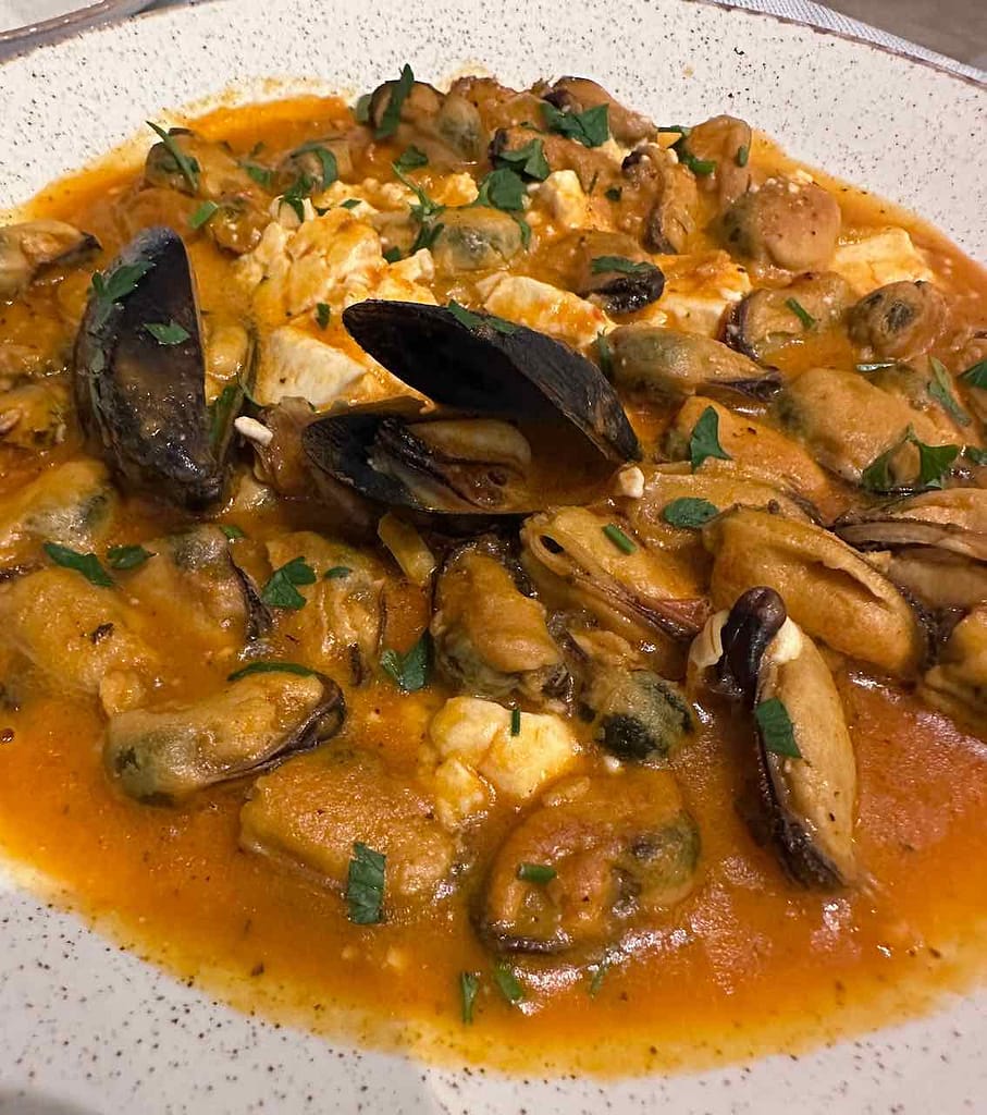 Insel Milos, Restaurant Trapatselis an der Hafenpromenade: Muscheln Saganaki mit Tomatensoße, Knoblauch und Feta © PetersTravel Peter Pohle